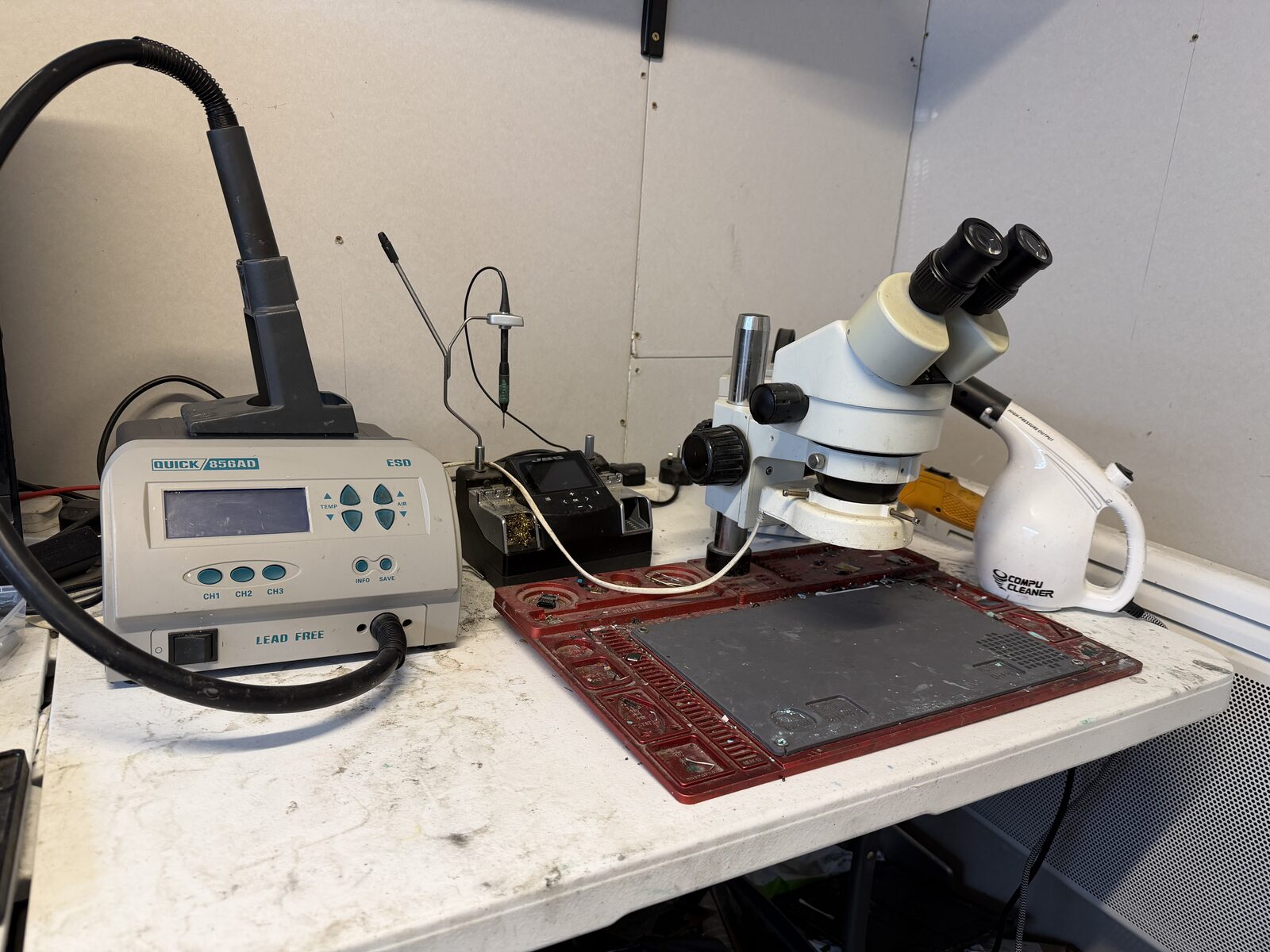 Wide shot of the Gravel Lane workshop — bench, soldering station, microscope, tool wall visible