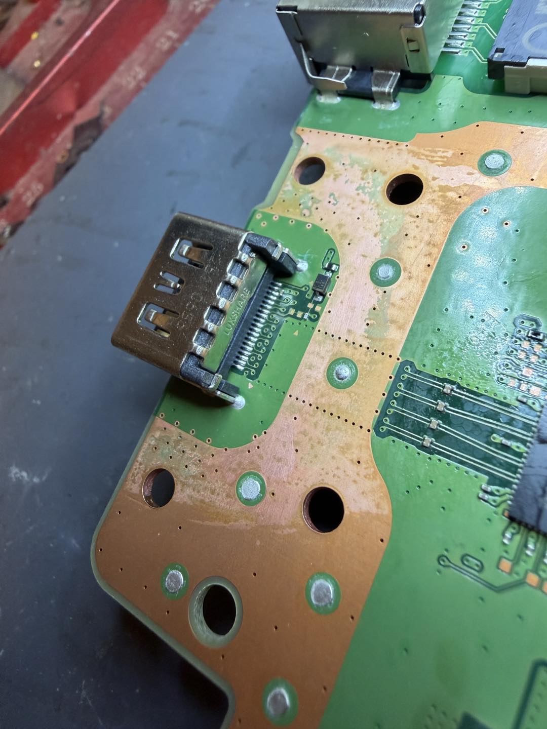 New HDMI port fitted and soldered — the finished repair under the microscope