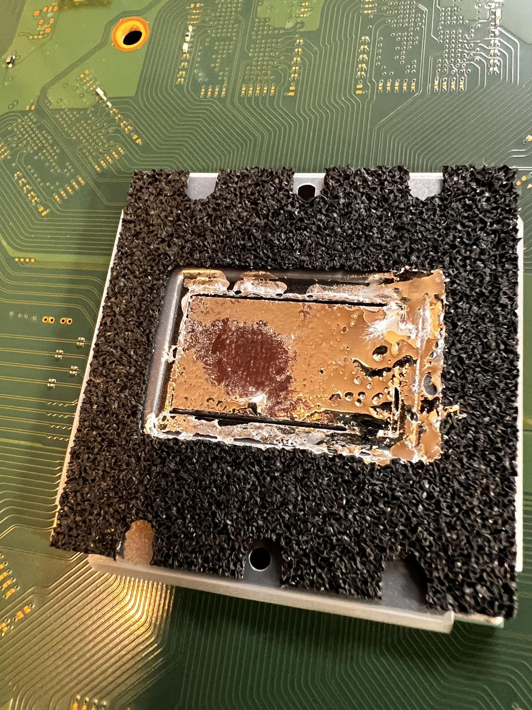 Close-up of PS5 APU showing bald spots in the liquid metal — the migration damage