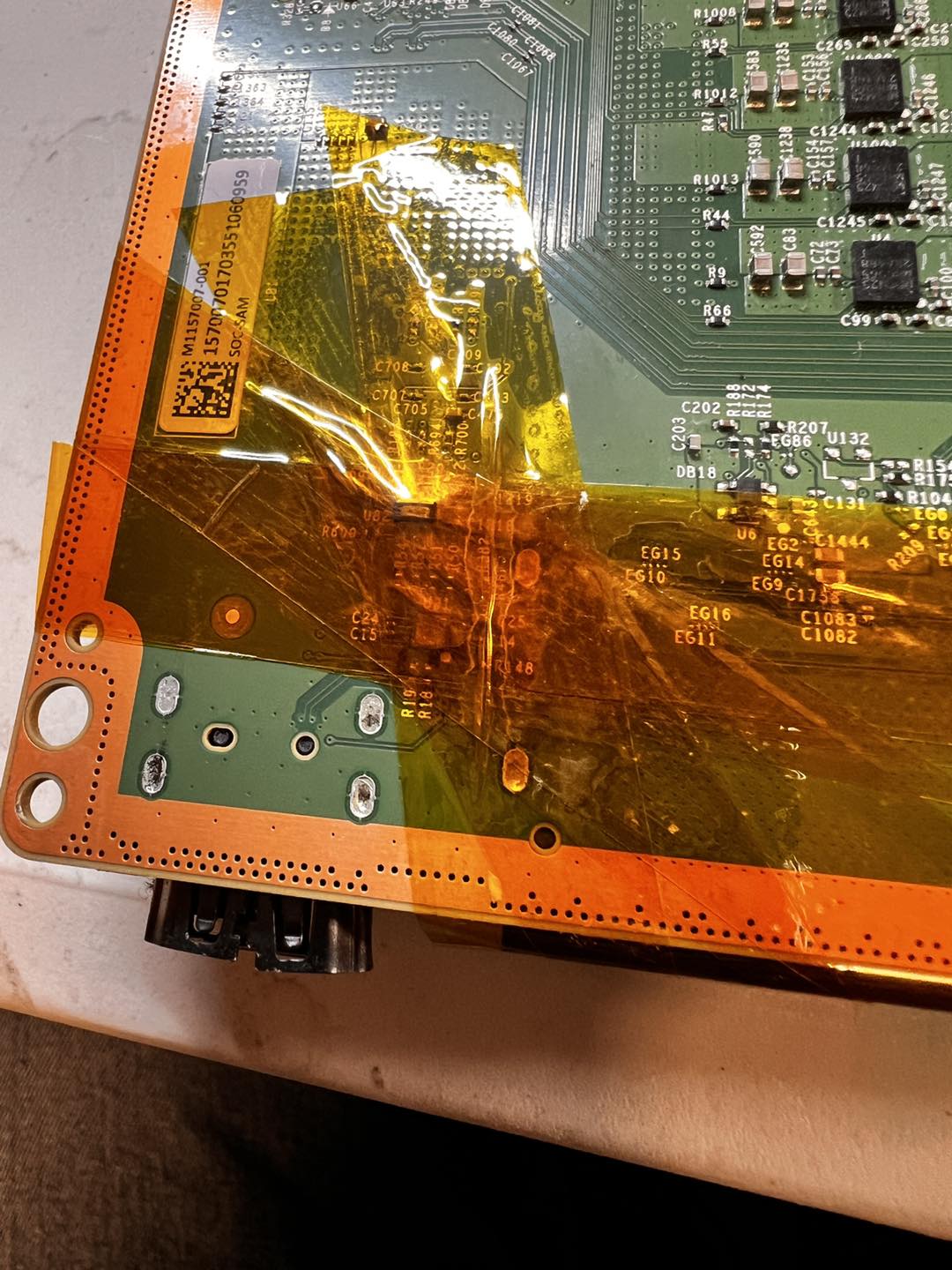 Xbox Series X opened up on the workbench, internals visible, HDMI port area highlighted